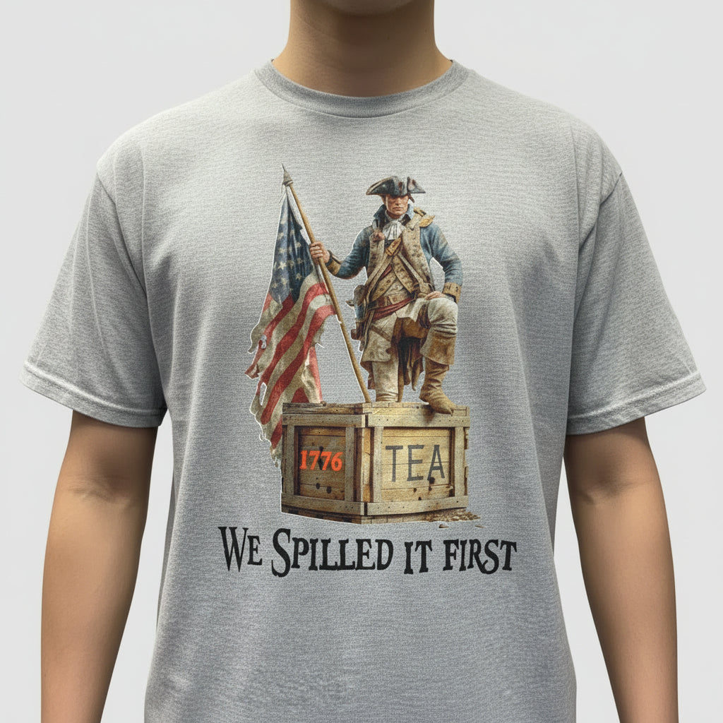 Gray t-shirt with American Revolution-themed graphic and text on a table.